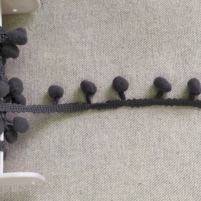 Fita decorativa cinza com bolas de tecido sobre fundo cinza