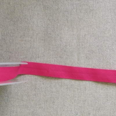 Fita têxtil cor-de-rosa sobre tecido creme com texto Cor 17