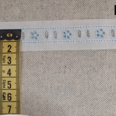 Fita têxtil branca com padrão azul e bege com fita métrica amarela ao lado e texto B3