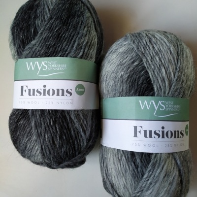 Dois novelos de lã cinzenta e preta Fusions da West Yorkshire Spinners com etiquetas verdes e brancas.