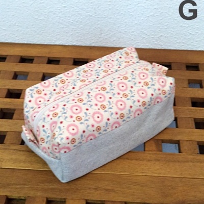 Bolsa de tecido com padrão floral e base cinza sobre superfície de madeira