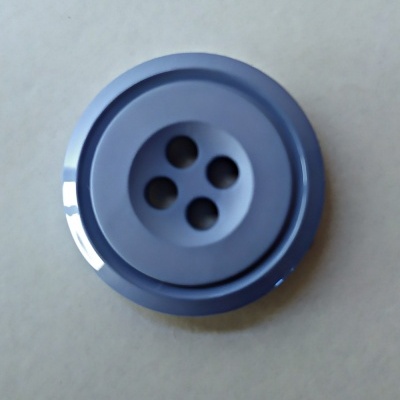 Botão redondo azul de plástico com quatro furos centrais sobre fundo cinza claro.