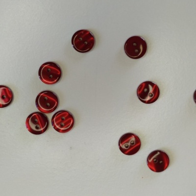 Botões redondos vermelhos translúcidos com dois orifícios em fundo branco