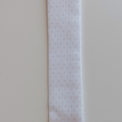 Tira branca com botão e clipe e letra O preta no fundo