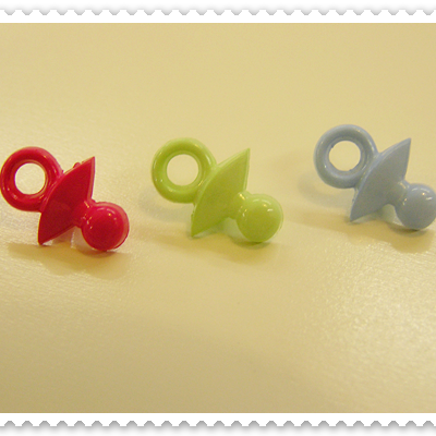 Três chuchas coloridas em linha sobre superfície amarela