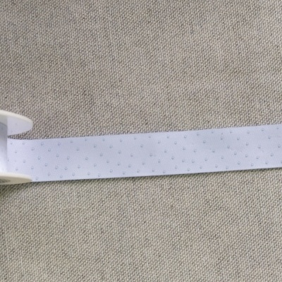 Fita branca com pintas azuis sobre tecido bege