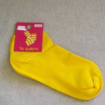 Meias amarelas com etiqueta rosa sobre superfície cinzenta