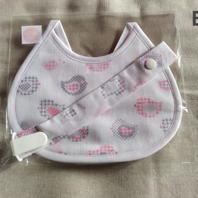 Babete e fita para chupeta branco com padrão de pássaros rosa e cinza em saco plástico