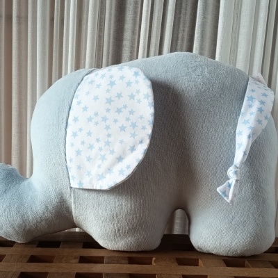 Pelucho elefante cinzento com orelhas brancas com estrelas azuis