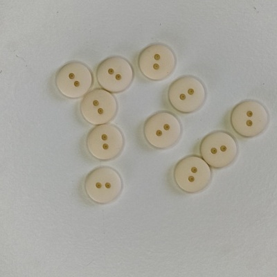 Botões brancos redondos com dois furos dourados no centro