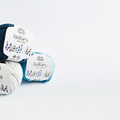 Três novelos de lã Natura Jazz Cotton nas cores azul escuro, branco e azul claro