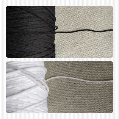 Novelos de cordão elástico preto e branco sobre tecido cinza