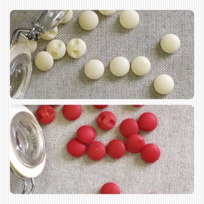 Fechos de pressão redondos brancos e vermelhos com ferramenta metálica sobre tecido bege