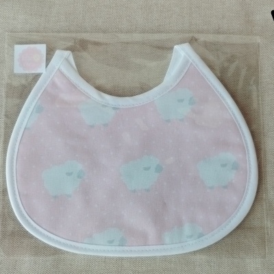 Babete para bebê rosa com ovelhas azuis claras e bordas brancas