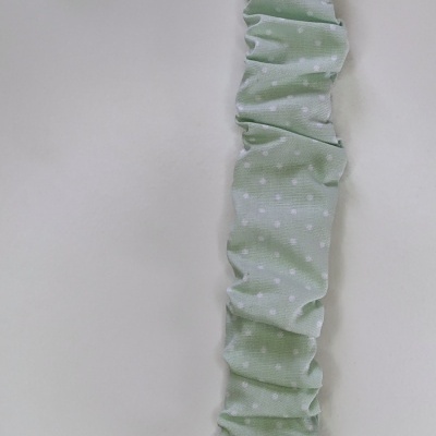 Prendedor para chupeta verde claro com bolinhas brancas e presilha branca.