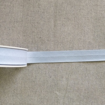 Fita elástica branca num rolo sobre fundo de tecido bege