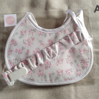 Babete com padrão floral e suporte para chupeta