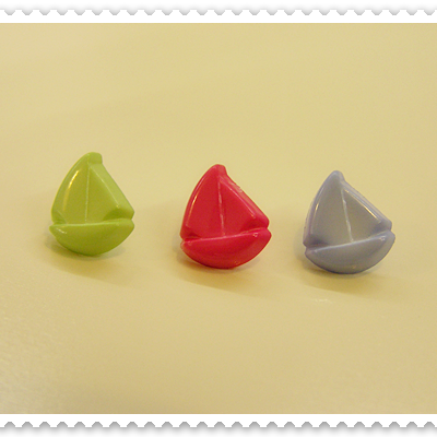 Três peões coloridos em forma de barco à vela