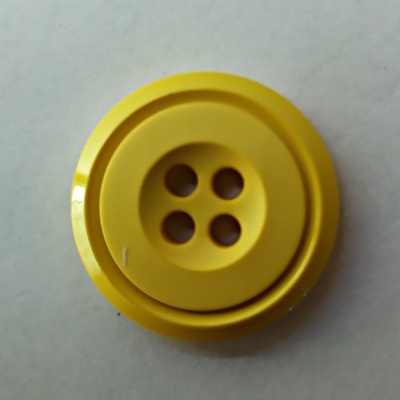 Botão amarelo redondo de plástico com quatro furos centrais