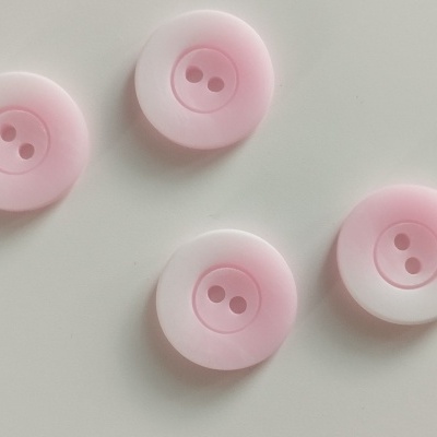 Quatro botões plásticos rosa claro com dois furos em superfície branca.