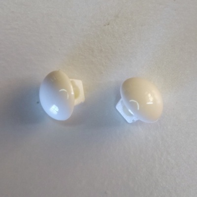 Dois botões de pressão brancos com superfície lisa sobre fundo branco