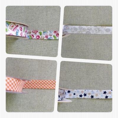 Rolos de fitas decorativas com diversos padrões coloridos sobre tecido cinza