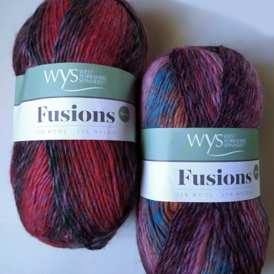 Dois novelos coloridos de lã Fusions da WYS com etiqueta verde e branca