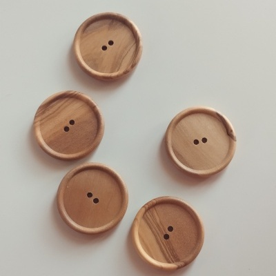 Cinco botões de madeira castanha clara redondos, 30 mm, com dois furos cada, sobre fundo branco.