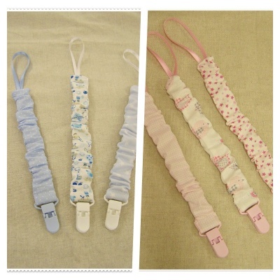 Seis tiras coloridas com clipes plásticos em tons azul, branco e rosa com padrões, sobre fundo bege.
