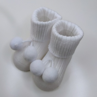Meias brancas para bebé com pompons e padrão canelado