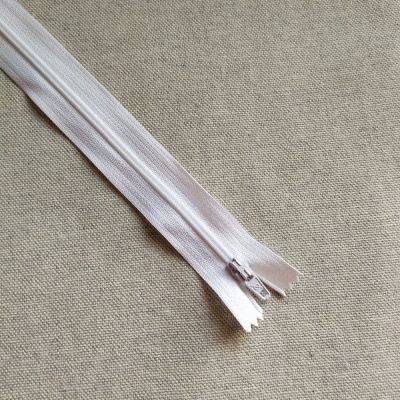 Fecho de correr branco sobre tecido cinza claro com texto Cor 501