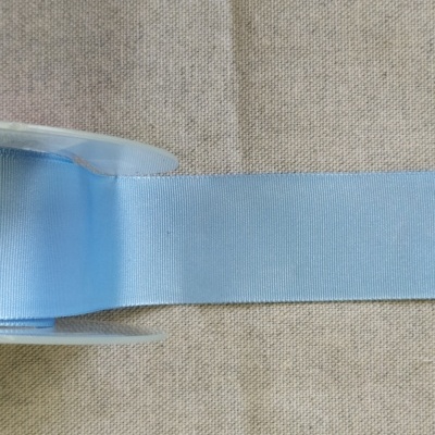 Rolo de fita azul sobre tecido bege com texto 'Azul'