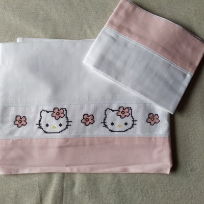 Conjunto de panos bordados com gato e flores sobre fundo neutro