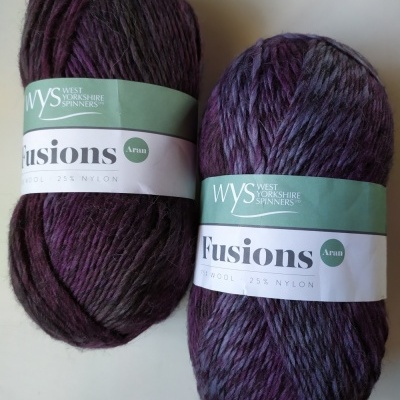 Dois novelos de lã roxa Fusions Aran da West Yorkshire Spinners com etiquetas verdes
