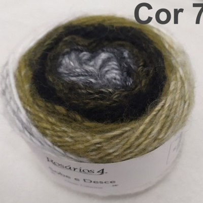 Novelo de fios de lã com tonalidades verdes, castanhas e creme, com rótulo branco e texto 