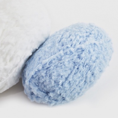 Objeto oval azul claro felpudo junto a objeto branco felpudo