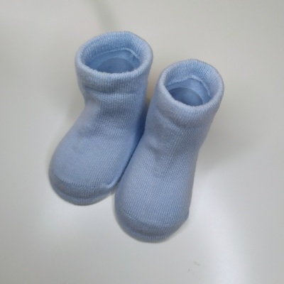 Meias botins azuis claras para bebé sobre fundo branco