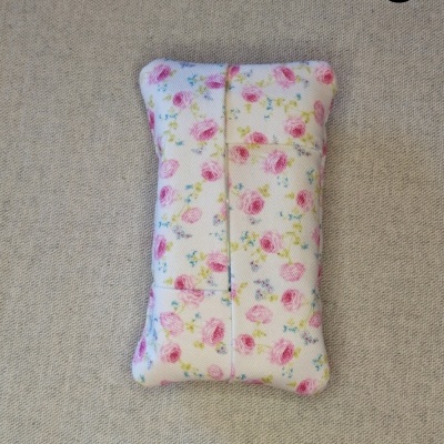 Almofada retangular pequena com padrão floral colorido sobre fundo branco