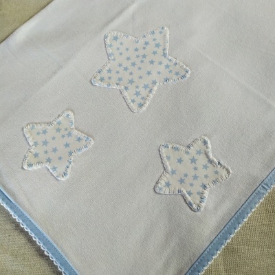 Manta branca com estrelas azuis e borda azul com renda