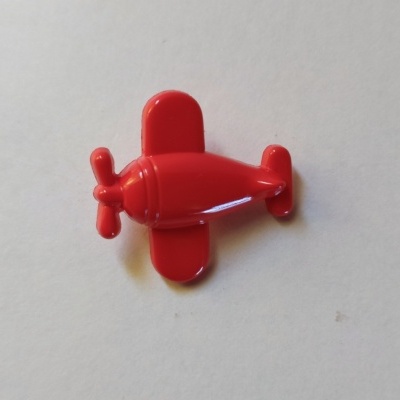 Pequeno avião de plástico vermelho sobre fundo branco