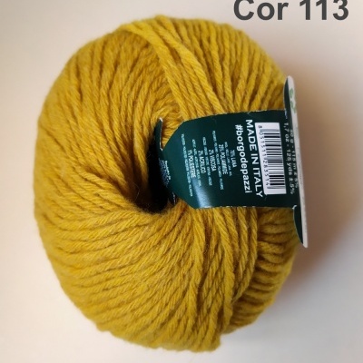 Novelo de lã amarelo-ocre com etiqueta verde escura, em superfície clara com texto Cor 113.