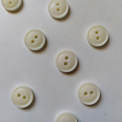 Botões redondos brancos com dois buracos sobre fundo branco