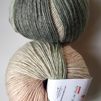 Dois novelos de lã em tons de verde, bege e rosa claro com etiqueta 'Made in Italy' e código Cor 415