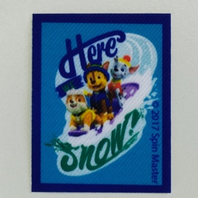 Adesivo colorido com personagens de desenho animado na neve e texto promocional.