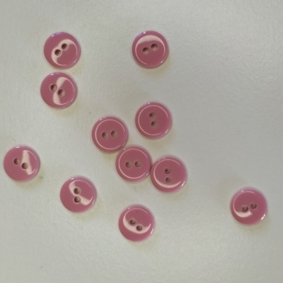 Dez botões cor-de-rosa com dois furos, sobre fundo branco