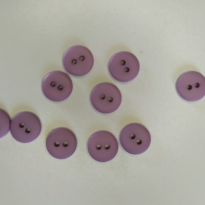 Dez botões roxos redondos com dois furos sobre fundo branco