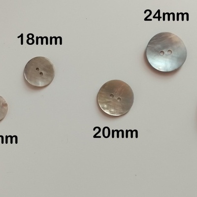 Botões redondos em vários tamanhos e tons metalizados sobre fundo branco