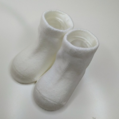 Meias brancas com cano curto sobre superfície branca