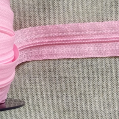 Fita de zíper rosa claro sobre tecido bege com texto 'Rosa'