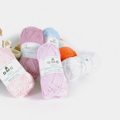Novelos de lã DMC 100% Baby Cotton em várias cores sobre superfície branca